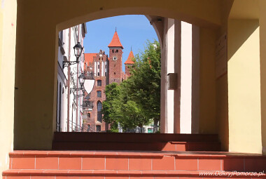 Gniew - spojrzenie przez podcienia na zamkową wieżę