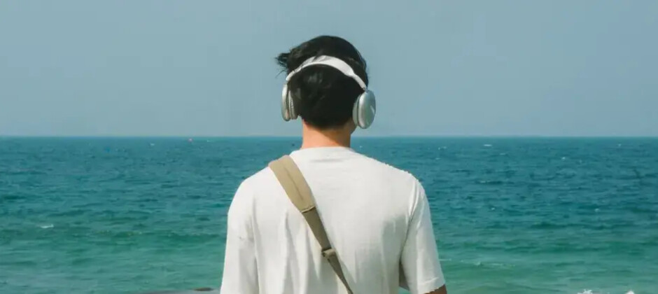 Plaża, spacer brzegiem morza i książka w słuchawkach. Jak wybrać audiobook idealny na urlop? Art. sponsorowany.