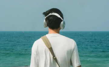 Plaża, spacer brzegiem morza i książka w słuchawkach. Jak wybrać audiobook idealny na urlop? Art. sponsorowany.